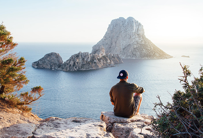 man sitting by the ocean